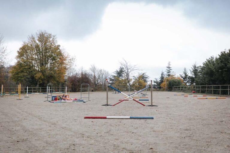 Des sauts et obstacles sont dispersés dans la carrière du centre équestre du Couzon