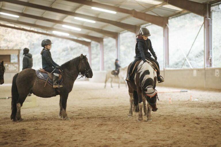 Des jeunes filles montent des chevaux dans le centre équestre du Couzon
