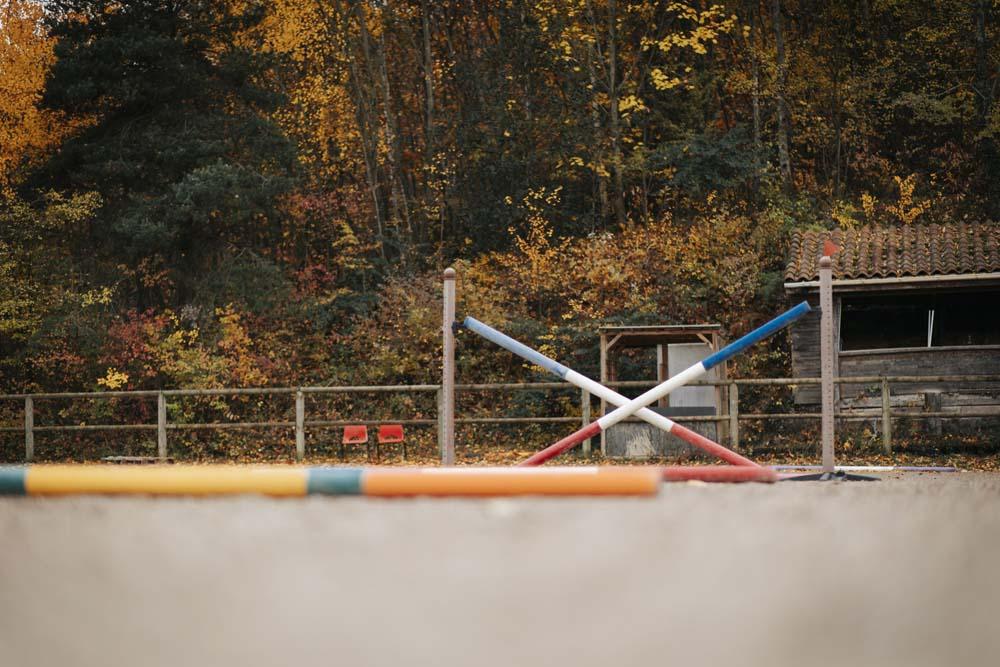 Des sauts et obstacles sont dispersés dans la carrière du centre équestre du Couzon