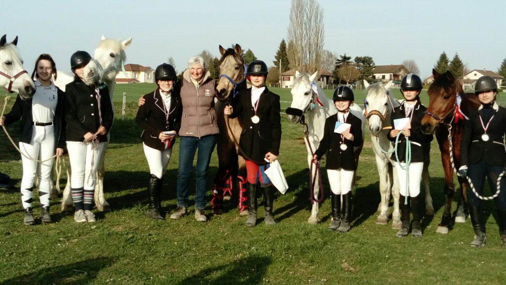 De jeunes femmes accompagnées de leurs chevaux présentent leurs prix lors d'une compétition équestre